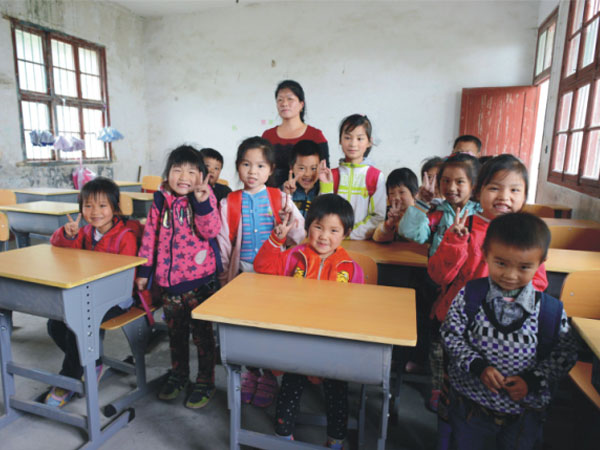 公司為一山村小學捐贈一批課桌椅，孩子們高興地和老師一起合影